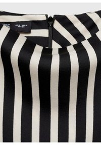 Tissu rayé vertical noir et blanc avec une fermeture éclair noire centrée et une petite étiquette de taille de vêtement partiellement visible en haut.