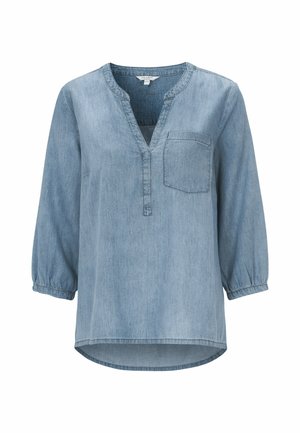 Helle blaue Denimbluse mit halbem Knopfverschluss, langen Ärmeln mit elastischen Bündchen und einer Brusttasche. Der Saum ist abgerundet und hinten etwas länger.