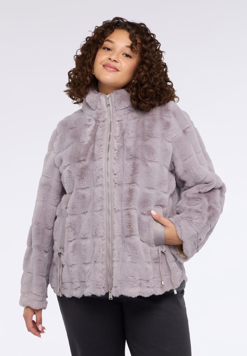 Kurtka z futra syntetycznego w jasnoszarym kolorze, z zamkiem błyskawicznym z przodu, wysokim kołnierzem i naszywanymi kieszeniami. Tkanina ma teksturowany wzór w formie kratki.