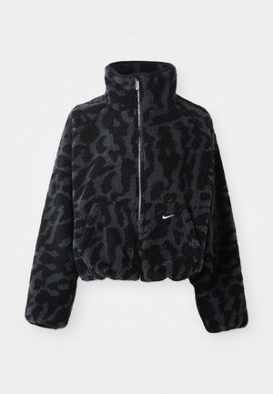 Afkortet sort og grå faux fur jakke med høj krave, lynlås foran og diskret leopardmønster. Har et lille hvidt logo på brystet.
