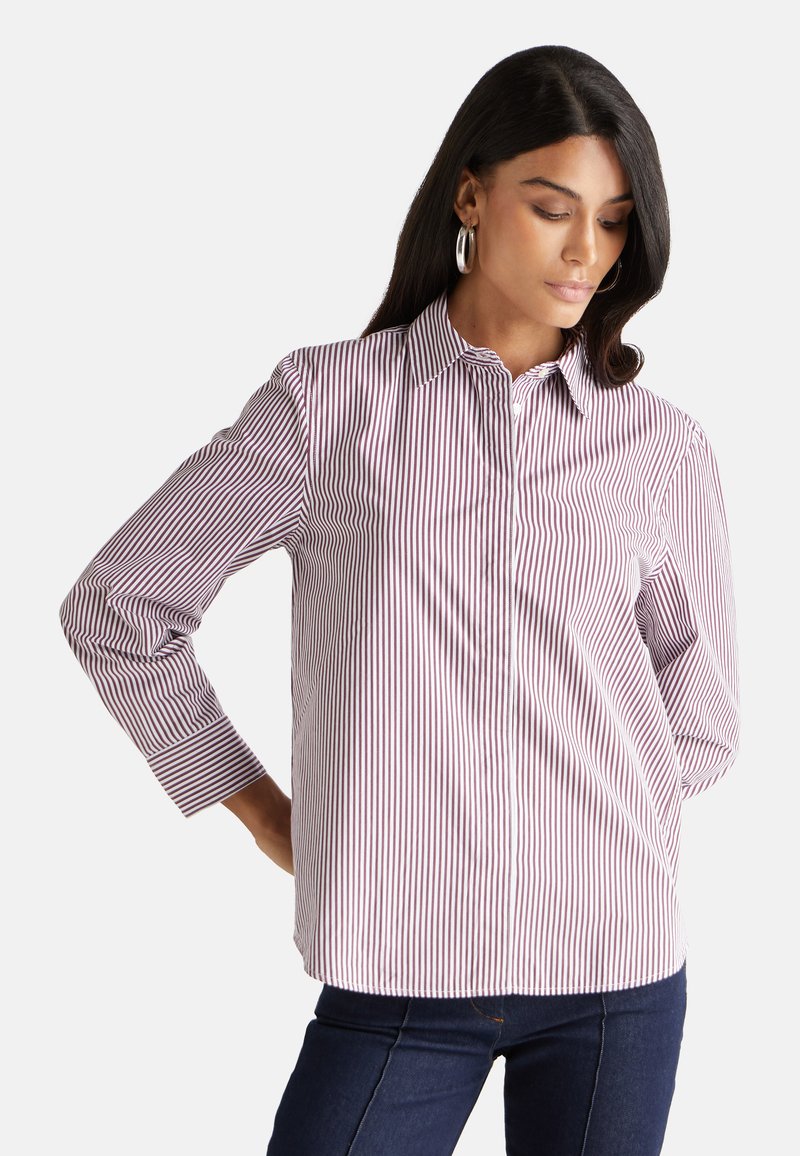 Camicia a righe bianca e rosso scuro, con colletto classico, maniche lunghe e una forma leggermente aderente.