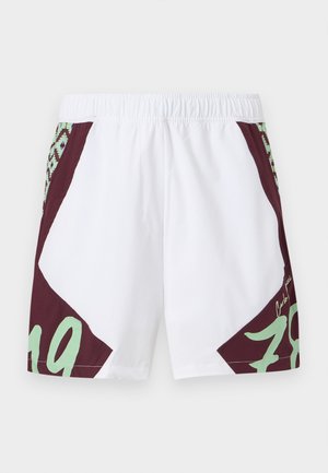Pantalones cortos blancos con detalles en granate y verde menta. Presentan un patrón geométrico, cinturilla elástica y el número "79" impreso en grande en el lateral.