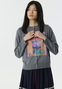 Cardigan en tricot gris avec un graphique coloré et pittoresque sur le devant, doté de boutons ronds et de poignets et d'ourlet côtelés.