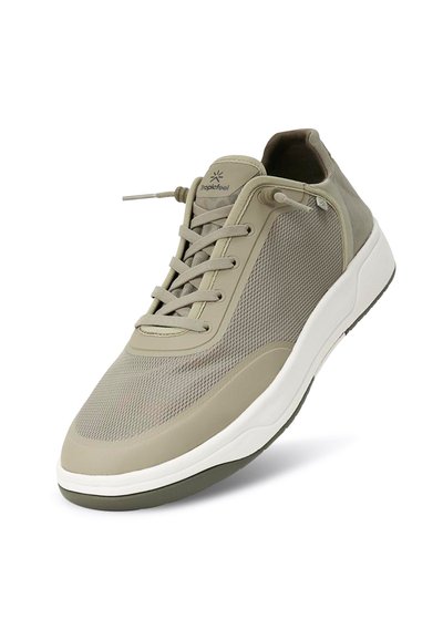 Lättviktig khaki sneaker med mesh-överdel, texturerade sidor, runda skor och en vit gummisula med en subtil grön accent.