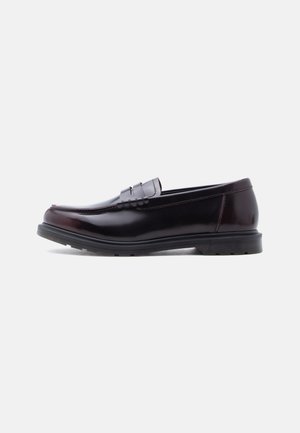 Dark brown leather penny loafer with black rubber sole, sleek design, and moc toe stitching, shown in side profile on plain background.