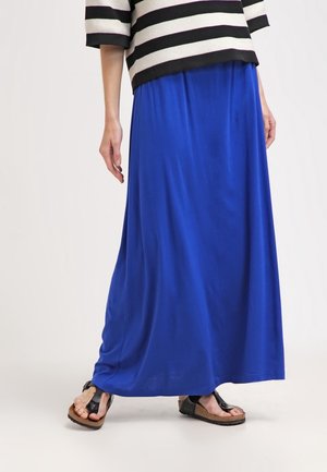 Lange blaue Maxirock aus weichem, fließendem Stoff, kombiniert mit einem schwarz-weiß gestreiften Oberteil. Das Outfit zeichnet sich durch eine lockere Passform und einen lässigen Stil aus.