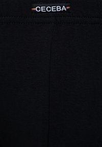 Tessuto in cotone nero elasticizzato con una superficie liscia. Presenta un'etichetta CECEBA visibile cucita in vita. Design semplice e minimalista.