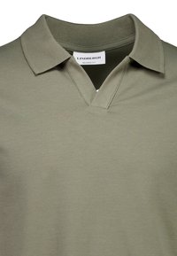 Oliwkowa koszulka polo o luźnym kroju, z klasycznym kołnierzykiem i dekoltem w kształcie litery V. Wykonana z miękkiego, gładkiego materiału.