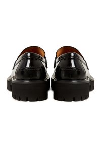 Zwarte patenten leren loafers met een chunky zwarte rubberen zool en een iets verhoogde hak, met stikdetails langs de randen.