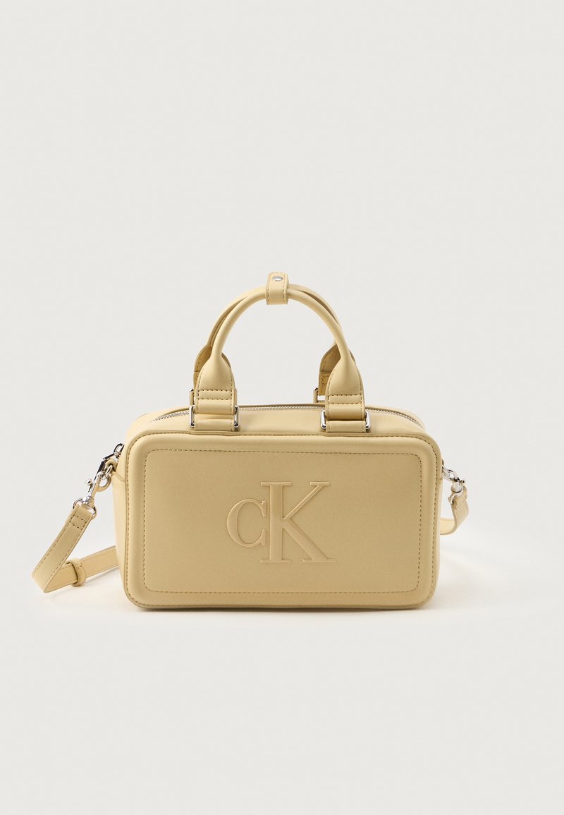 Bolso de mano de imitación cuero amarillo con asas dobles, correa de hombro desmontable, forma rectangular, logo "CK" en relieve y acentos de hardware plateado.