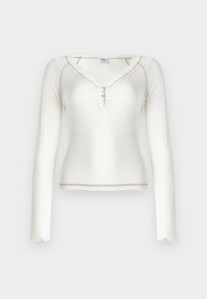 Witte lange mouwen ribbeltop met een kanten halslijn, knoopsluiting en afgeronde zoomafwerking. Zachte textuur, aansluitend ontwerp.