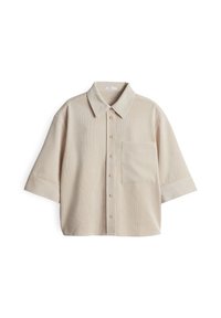 Chemise beige à manches courtes avec boutons, poche poitrine et col classique, posée à plat sur fond blanc.