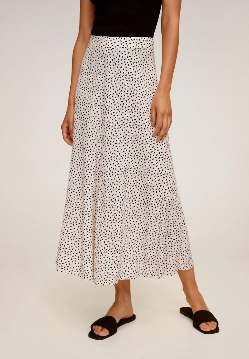 Hvid, flydende maxi skirt med et prikket sort print, lavet af letvægtigt materiale; har en høj talje og en udvidet design for nem bevægelse.