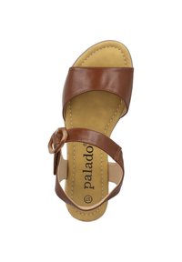 Brązowe skórzane sandały z zamkniętym noskiem, szerokim paskiem na stopie, regulowanym zapięciem oraz wyściółką w kolorze beżowym.