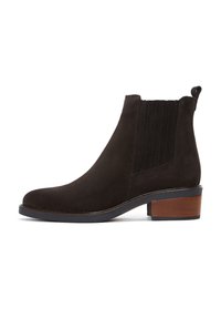 Stivaletto in suede marrone con punta arrotondata, pannelli laterali elasticizzati e tacco a blocco con un accento in legno. Texture morbida e design minimale.