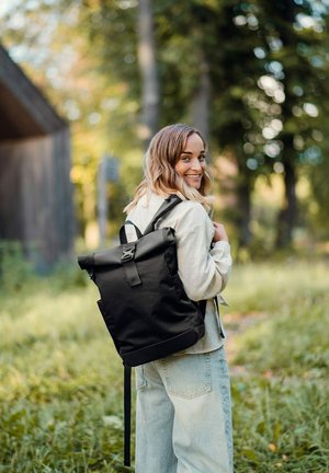 Černý batoh s rolovacím uzávěrem vyrobený z odolné tkaniny, s nastavitelnými popruhy, stříbrnou sponou a minimalistickým designem.