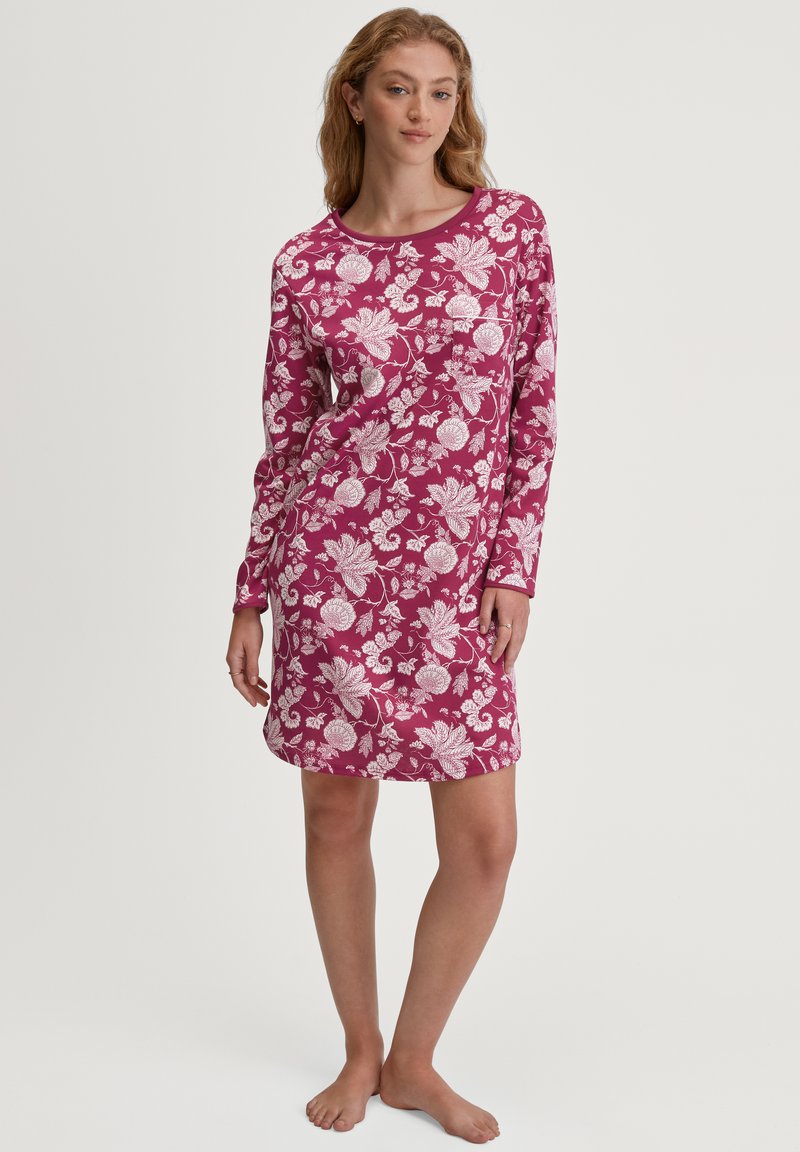 Camicia da notte a maniche lunghe in cotone bordeaux con motivo floreale bianco, scollo rotondo e vestibilità morbida. Tessuto liscio e lunghezza fino a metà coscia.