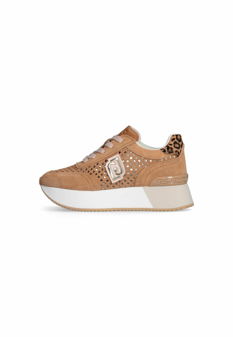 Barna velúr sneaker perforált mintázattal, kontrasztos bézs talppal, fémes logóval és leopárdmintás kiemeléssel a sarokon.