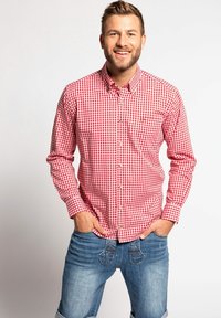 Rot-weiße kariertes Hemd mit Button-Down-Kragen, langen Ärmeln und einer linken Brusttasche, kombiniert mit blauen Jeans.