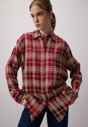 Rødt og beige ternet skjorte med spids krave, knaplukning foran, lange ærmer og løs pasform. Stoffet har en glat, blank overflade.