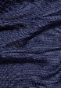 Tejido de punto azul marino con una textura de canales finos, que presenta una costura constante y un brillo sutil, creando una apariencia suave y delicada.