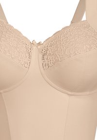Beige lace bra with a smooth fabric finish, floral lace trim on cups, a small satin bow at the center, and wide adjustable straps.