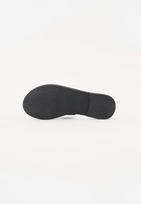 Svart skosåle med rund form, teksturert overflate og flat hæl; gummimateriale med en lett glans og jevne kanter.