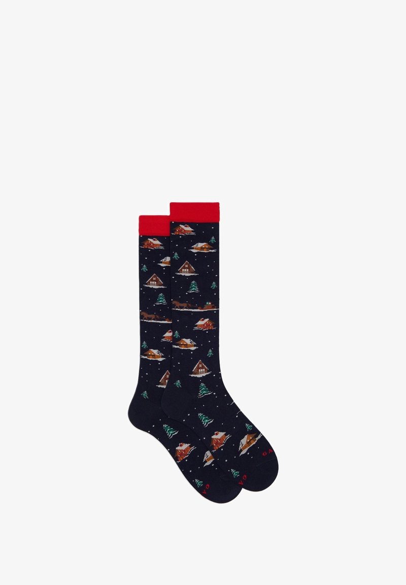 Calze al ginocchio blu navy con polsini rossi, raffiguranti un paesaggio invernale di cabine, alberi e fiocchi di neve in un motivo ripetuto.