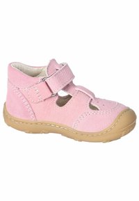 Růžová semišová bota s hnědou gumovou podrážkou, která má suchý zip a výřezy pro ventilaci. Šité detaily dodávají texturu.