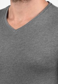 Grijs V-hals T-shirt van katoen met een zachte textuur en een casual pasvorm. De halslijn heeft een gladde afwerking die naadloos overgaat in het shirt.