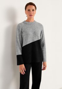 Grå och svart färgblockerad tröja, tillverkad i mjuk ull, har en rundad halsringning och ribbade ärmslut, med en diagonal design över bröstet.