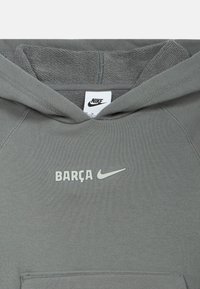 Gray Nike hoodie with "BARÇA" and Nike swoosh logo centered below the collar and a front kangaroo pocket visible.