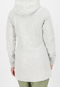 Harmaa pitkähihais sweatshirt, jossa on huppu. Siinä on rento istuvuus, teksturoitu kangas ja kaareva helma, nähtynä takaa.