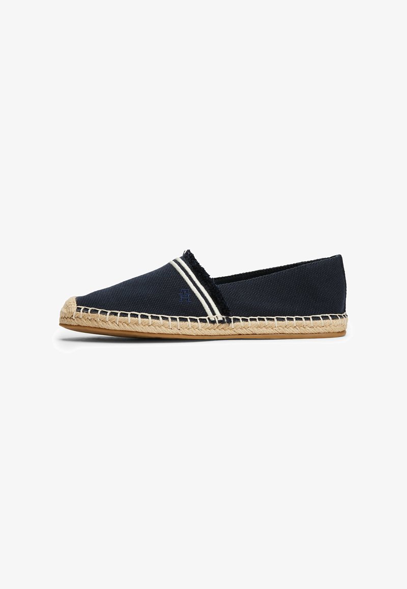 Espadrille in tela navale con strisce bianche, suola in corda di juta e texture intrecciata. Punta arrotondata e design minimalista.