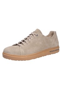 Baskets en suède beige avec un bout arrondi, à lacets et semelle en caoutchouc. Comprend un accent subtil le long du bord de la semelle.