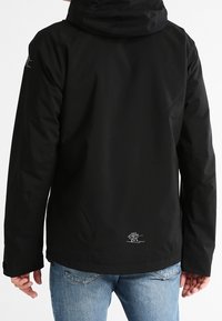 Czarna wodoodporna kurtka z kapturem, gładka w dotyku, z haftowanym logo na dolnej części pleców. Posiada luźny krój i długie rękawy.
