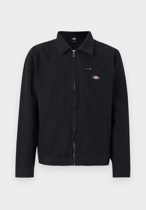 Crna jakna na patent s ovratnikom, dva bočna džepa i mali džep na prsima sa zatvaračem, na kojem se nalazi okrugli logotip.