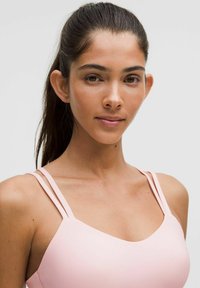 Light pink swimwear top with double thin straps, a rounded neckline, and smooth texture. Designed for comfort and ease of movement.