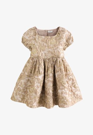 Vestido beige para niño pequeño con mangas abullonadas, cintura fruncida y patrón jacquard floral dorado, con escote redondo y cierre de botones en la espalda.