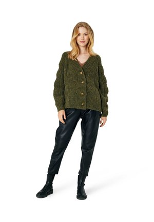 Groene gebreide cardigan met V-hals, gemaakt van textuurstof, vier grote knopen en een ontspannen pasvorm, gecombineerd met zwarte faux leren broeken.