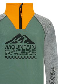 Fleece mikina s zeleným telom, oranžovým golierom a sivými rukávmi. Obsahuje čiernu grafiku hory a text "MOUNTAIN RACERS". Zapínanie na zips.