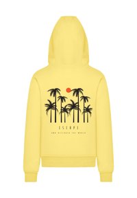 Gelbe Kapuzenjacke mit einem grafischen Design von schwarzen Palmen und einer roten Sonne. Darunter steht der Text "ESCAP3 AND DISCOVER THE WORLD".
