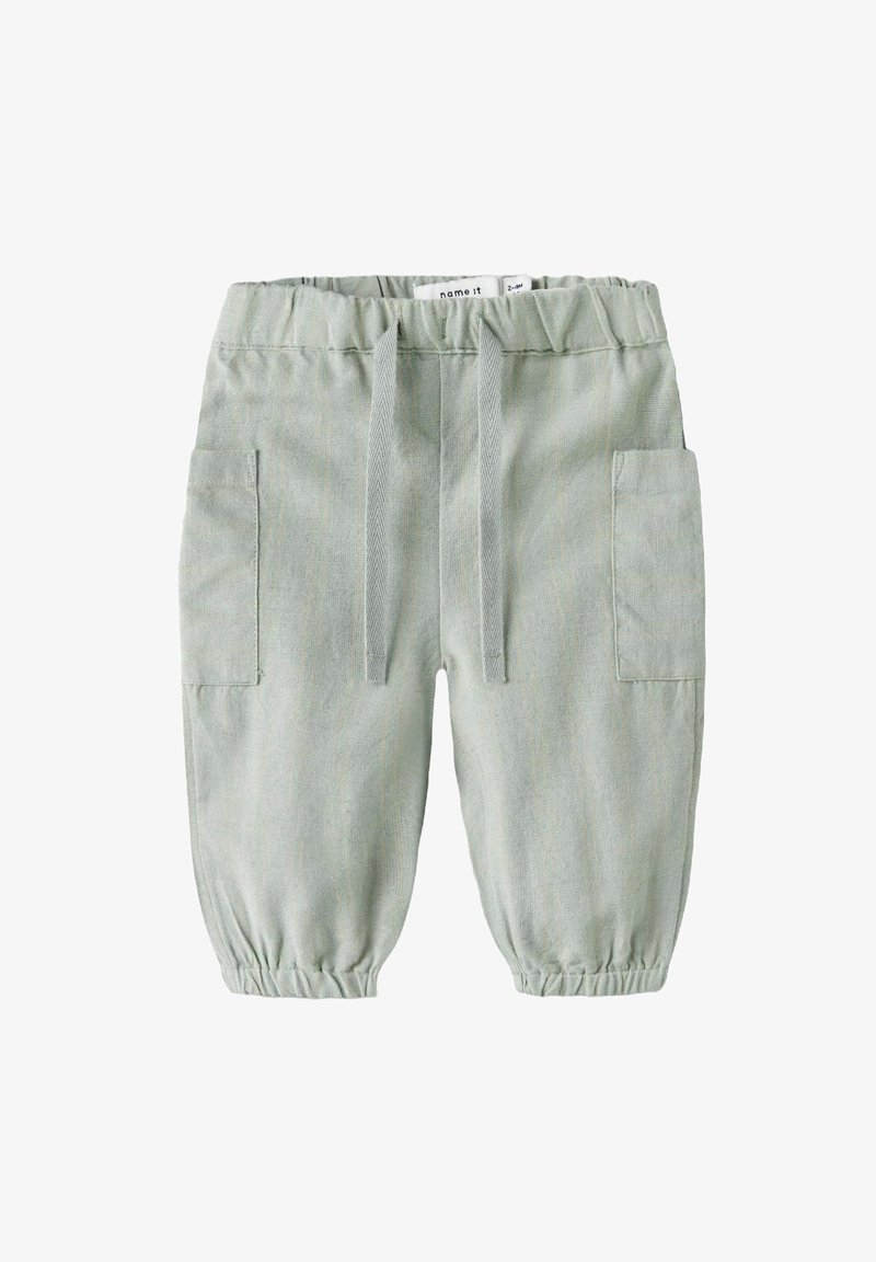 Pantalons cargo vert clair avec taille élastique, deux poches latérales et poignets élastiques aux chevilles. Fabriqués en tissu doux et texturé.