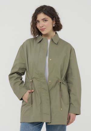 Giacca di cotone verde oliva con collo a camicia, cordoncini regolabili in vita e due tasche laterali. Tessuto morbido, vestibilità comoda.