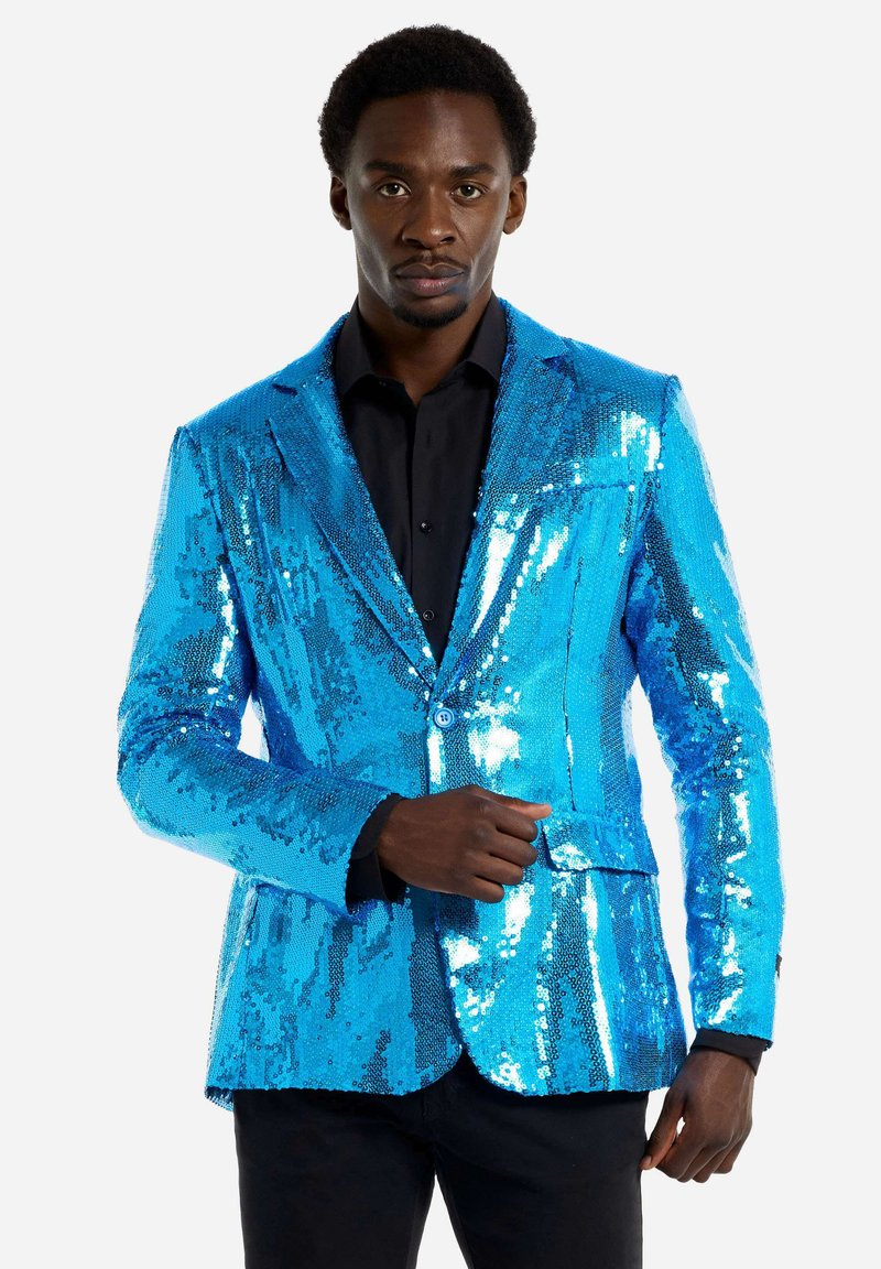 Mėlynas blizgučiais pasidengęs švarkas, turintis pritaikytą siluetą, su vienu mygtuku užsegamas ir su išpjautomis apykaklėmis, užsidėtas ant juodos marškinių.