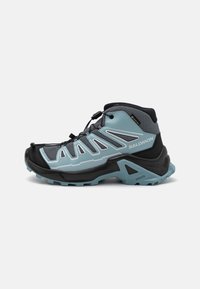 Mid-cut hiking shoe featuring a black and light blue design, mesh upper, rubber toe cap, and aggressive tread pattern on the sole.