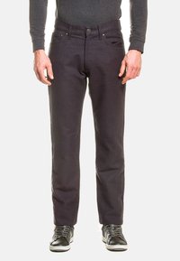 Jeans grigio scuro in cotone, con taglio dritto, cinque tasche, chiusura con bottone e dettagli in metallo. Indossati con sneakers nere.