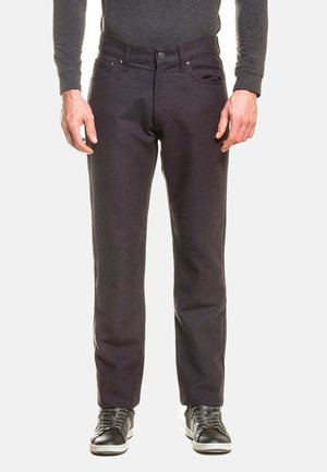 Jeans grigio scuro in cotone, con taglio dritto, cinque tasche, chiusura con bottone e dettagli in metallo. Indossati con sneakers nere.