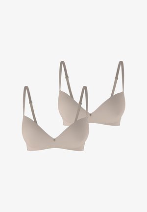 Twee beige, naadloze beha's met verstelbare bandjes, driehoekige cups, lichte vulling en een kleine decoratieve accent in het midden.