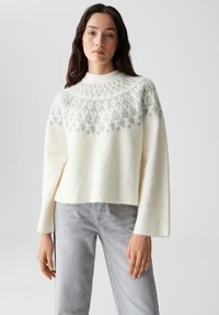 Maglione cropped color crema con scollo rotondo, caratterizzato da un yoke a motivo grigio chiaro e polsini a coste, realizzato in un morbido tessuto testurizzato.